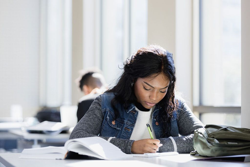 Girl concentrates on schoolwork at college